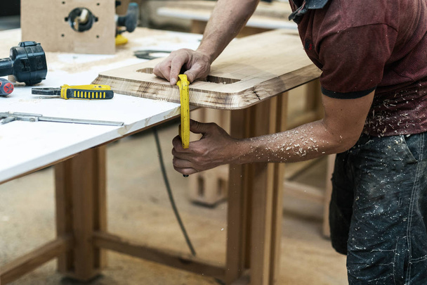 Концепция высококачественной древесины. Профиль боковой вид обрезанный фото cabinetmaker ручной ремонт дерева на столе сделать мебель в гараже или мастерской
 - Фото, изображение