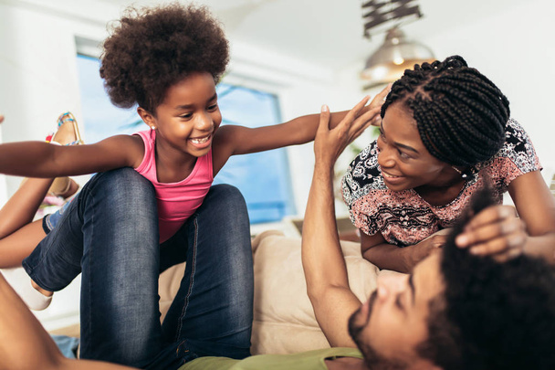 Afro-Amerikan ailesi evde birlikte vakit geçiriyor. Eğleniyorlar. - Fotoğraf, Görsel