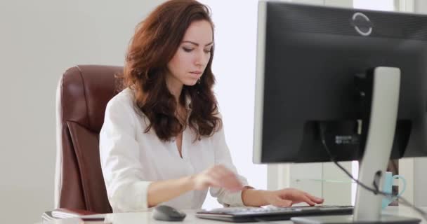 Mulher de negócios bonita trabalhando no escritório olhando para monitor de computador
 - Filmagem, Vídeo
