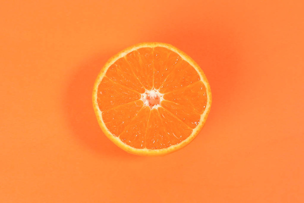 Mandarin Orange Fruit kawałek połowę na pomarańczowym tle  - Zdjęcie, obraz