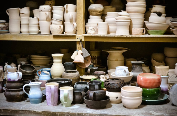 много различных керамики, стоящих на полках в мастерской
 - Фото, изображение