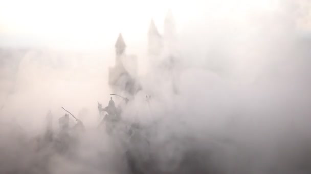 Medieval battle scene with cavalry and infantry. Silhouettes of figures as separate objects, fight between warriors on sunset foggy background. Selective focus - Footage, Video