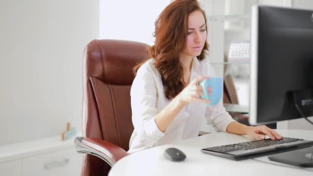 Hermosa mujer de negocios trabajando en la oficina bebiendo café
 - Metraje, vídeo