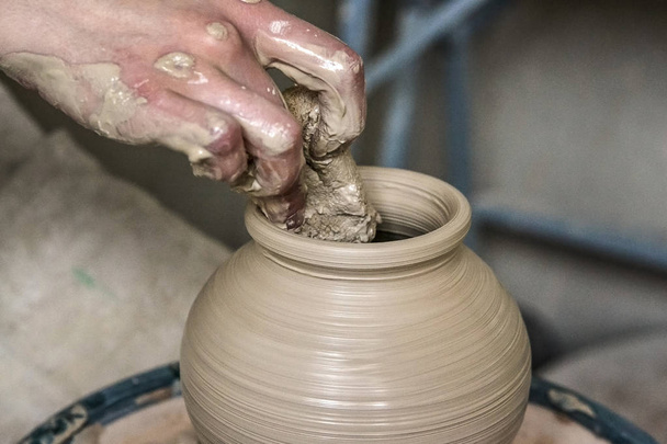 Mãos de homem e ferramenta fazendo jarro de argila macro
. - Foto, Imagem