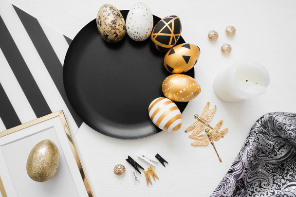 Happy Easter background with golden decorated eggs on black plate isolated on white background. Trendy flat lay easter.  - Fotografie, Obrázek