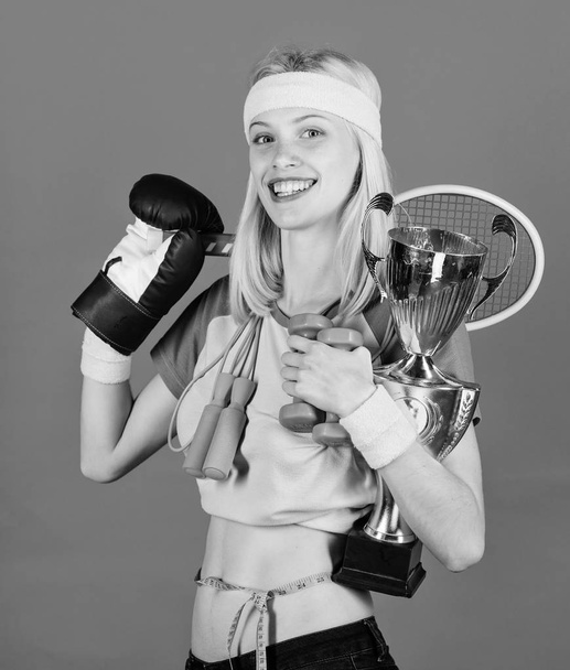 Girl successful modern woman hold golden goblet of champion. Woman good in tennis jumping boxing fitness sport. How to find time for everything. Sport champion. Fitness champion. Champion concept - Foto, Imagem