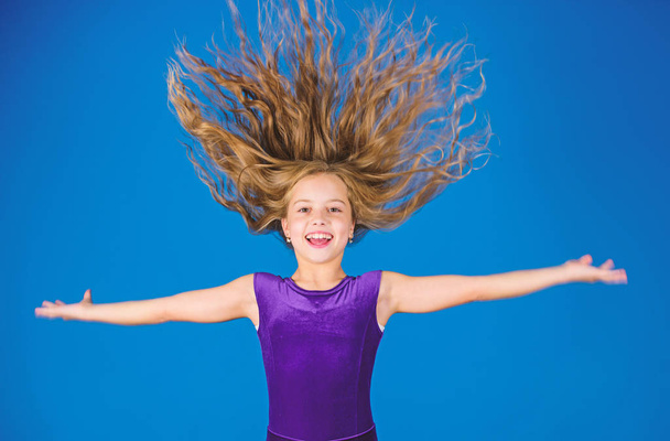 Ballroom latin dance hairstyles. Kid girl with long hair wear dress on blue background. Hairstyle for dancer. How to make tidy hairstyle for kid. Things you need know about ballroom dance hairstyle - Φωτογραφία, εικόνα