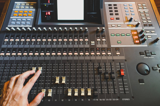 sound engineer hand working on sound mixing console in recording studio. music production, broadcasting concept - Foto, immagini