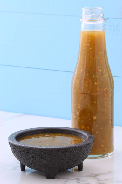 Ambachtelijke Mexicaanse tomatillo saus op retro vintage carrara marmeren setting met een kruidig milde hete smaak perfect voor al uw Mexicaanse, tex-mex recepten en zijden. - Foto, afbeelding