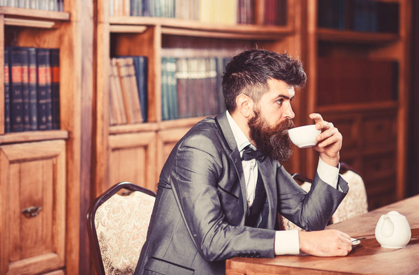 Mature man with calm face enjoys afternoon tea. - Фото, изображение