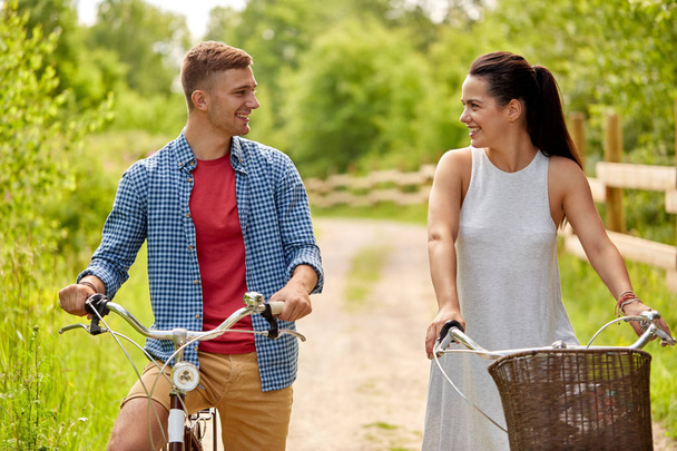ευτυχισμένο ζευγάρι με ποδήλατα στο πάρκο καλοκαίρι - Φωτογραφία, εικόνα
