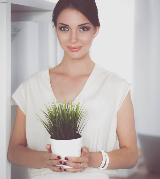 Beautiful woman holding pot with a plant - Foto, Imagen