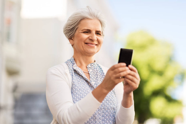 happy senior woman with smartphone in summer - Фото, изображение