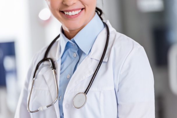 Обрезанный вид улыбающейся женщины-врача со стетоскопом
 - Фото, изображение