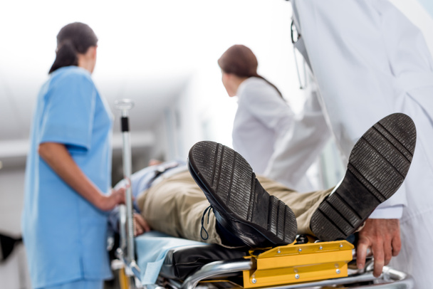Médecins et infirmières transportant un patient inconscient sur un brancard
 - Photo, image