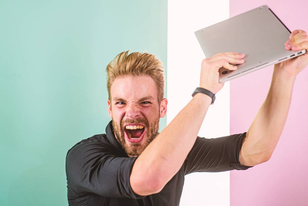 Annoying advertisement promoting brands on internet makes people go crazy angry aggressive. Man laptop annoyed by ads. Internet advertisement. Guy stylish appearance going mad while works laptop - Photo, image