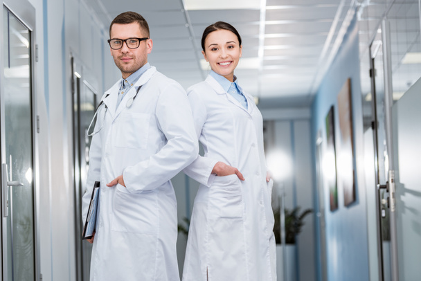 Confident doctors in white coats standing with hands in pockets - Photo, Image