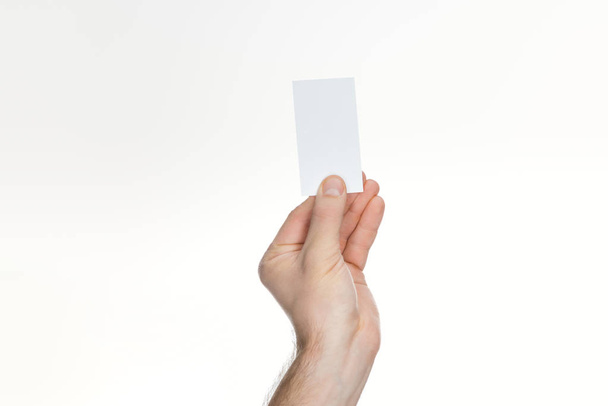 visão parcial do homem segurando cartão em branco e vazio no fundo branco com espaço de cópia
 - Foto, Imagem