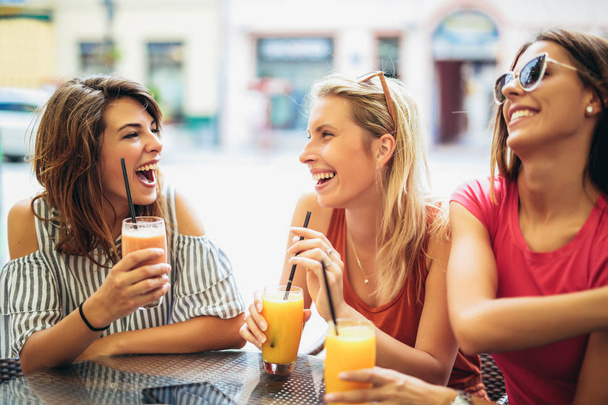 Три прекрасных друга в кафе веселятся
 - Фото, изображение