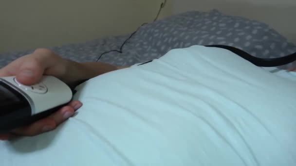 hombre utiliza el masajeador dispositivo para los ojos y la cabeza, aliviar la fatiga, la relajación, el descanso después de trabajar en un ordenador portátil
 - Metraje, vídeo