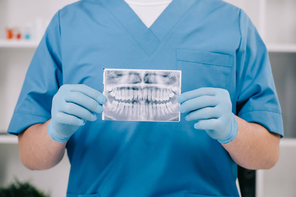 περικοπεί προβολή ορθοδοντικός κρατώντας ακτινογραφία δοντιών στην κλινική - Φωτογραφία, εικόνα