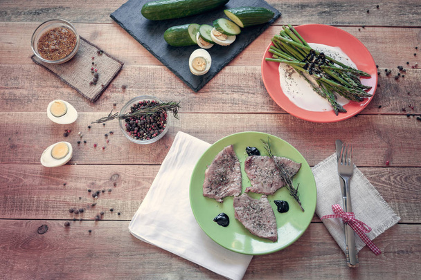 Mittagessen mit Steaks und Spargel auf Holzboden - Foto, Bild