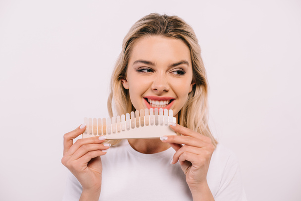 belle femme souriante tenant palette de couleurs des dents isolé sur blanc, concept de blanchiment des dents
 - Photo, image