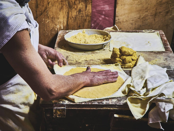 Um cozinheiro fazendo Tortilhas em uma mesa rústica de madeira
. - Foto, Imagem