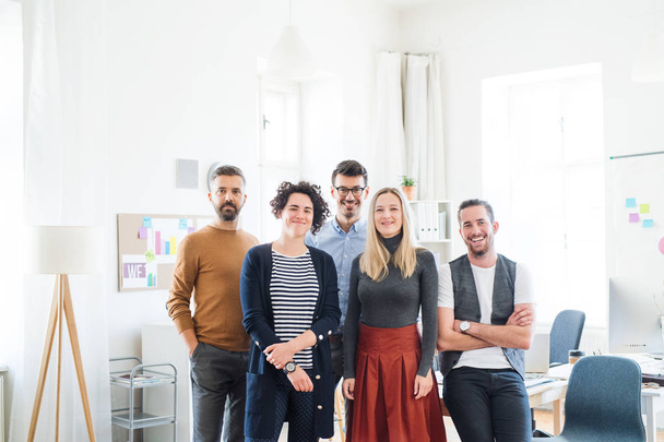 Um retrato do grupo de jovens empresários em pé em um escritório moderno
. - Foto, Imagem