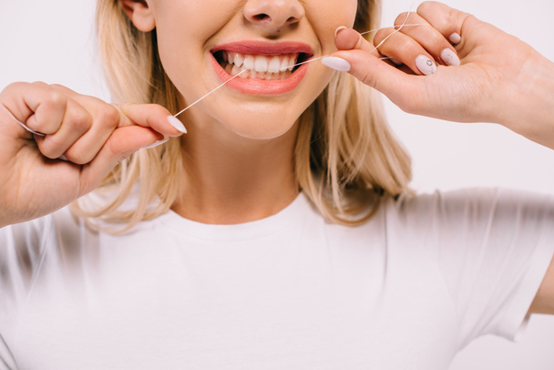 частковий вигляд жінки, що розлітається зубами з зубною ниткою ізольовані на білому
 - Фото, зображення