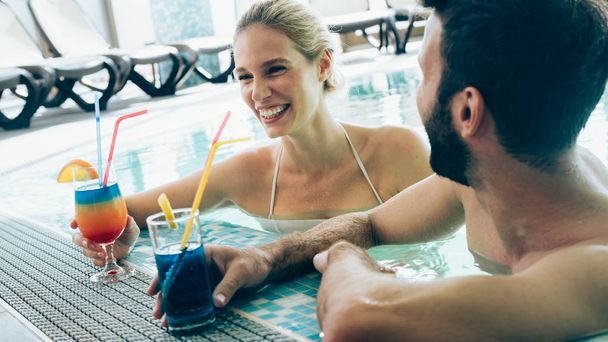 Feliz pareja atractiva relajarse en la piscina spa
 - Foto, imagen