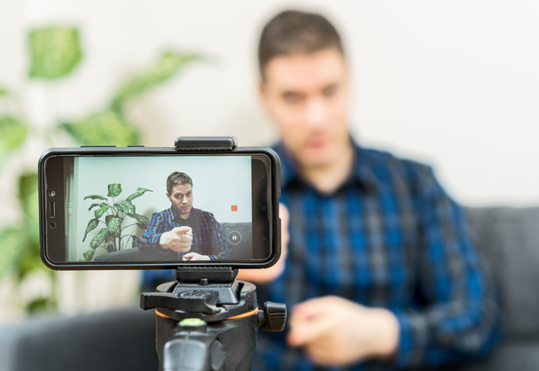 Pohledný muž dělat video blog. Zaměřit na smartphone. - Fotografie, Obrázek