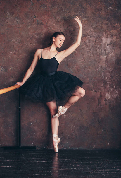 Ballet danser ballerina in prachtige zwarte jurk tutu rok poseren in loft studio - Foto, afbeelding