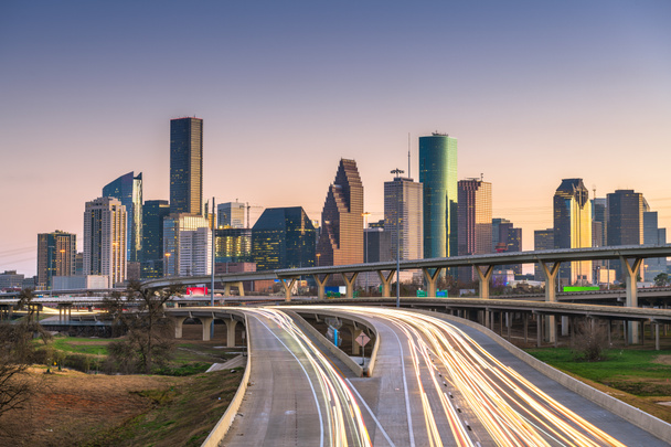 De skyline van de binnenstad stad van Houston, Texas, Usa en snelweg in de schemering. - Foto, afbeelding