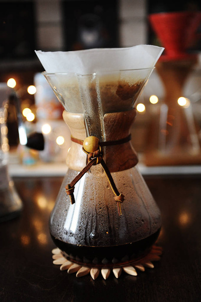 Handmatige alternatief brouwen koffie met papieren filter op de achtergrond van de lichten - Foto, afbeelding