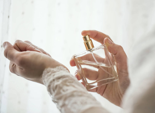 Panna Młoda ręce stosowanie perfum na jej nadgarstku, zbliżenie selektywnej ostrości - Zdjęcie, obraz