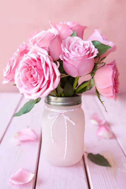 Lush pink roses on pink in a vintage jar - Photo, image