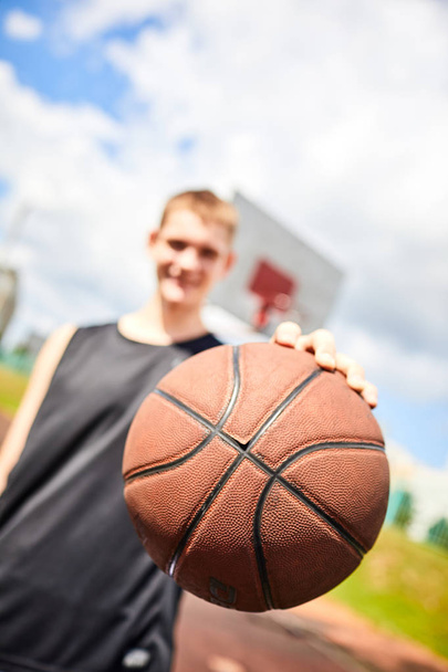 uomo che tiene la palla mentre gioca a basket all'aperto
 - Foto, immagini