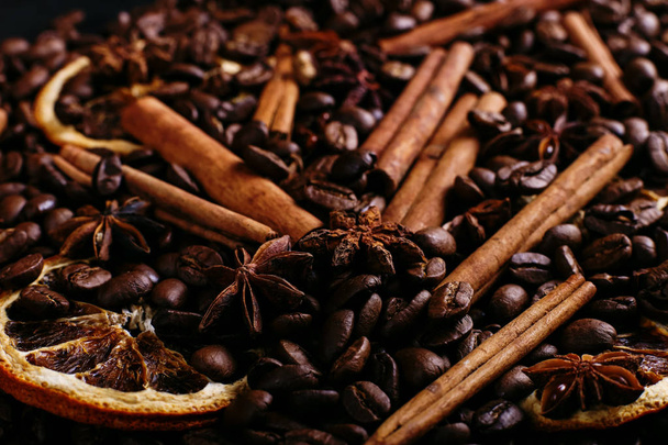 Cinnamon sticks, star anise, coffee beans and dried orange on kitchen table. Fragrant spices for coffee drink, close-up. - Zdjęcie, obraz