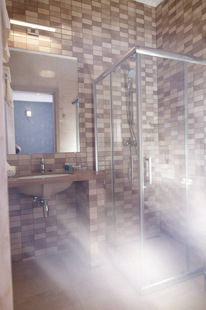 Salle de bain chambre confortable, douche, carrelage mosaïque, lavabo
 - Photo, image