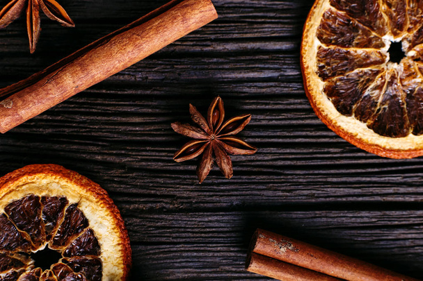 Cinnamon sticks, star anise and dried orange on kitchen table. Fragrant spices, closeup. - Foto, Imagem
