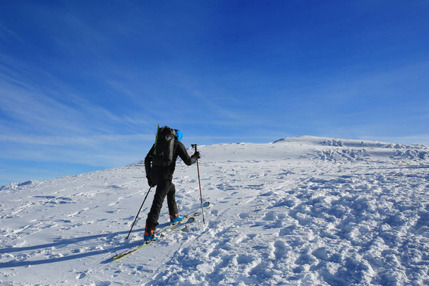 Le skieur monte au sommet de la montagne
 - Photo, image