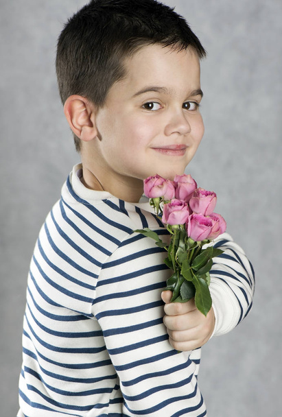 Boy in a striped sweatshirt with a bouquet of pink roses. Concept for mother's day, Valentine's day, love, forgiveness - Fotografie, Obrázek