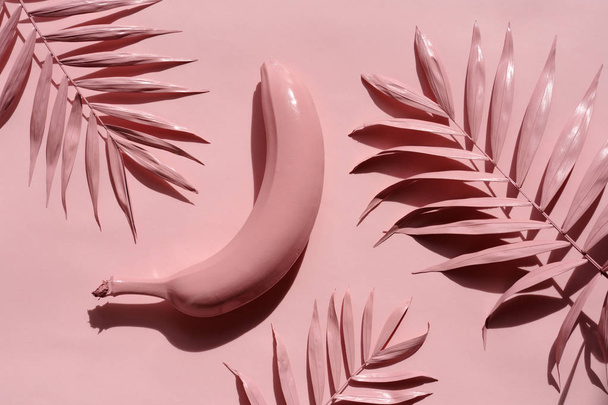 pink banana with palm leaves on a pink background - Zdjęcie, obraz