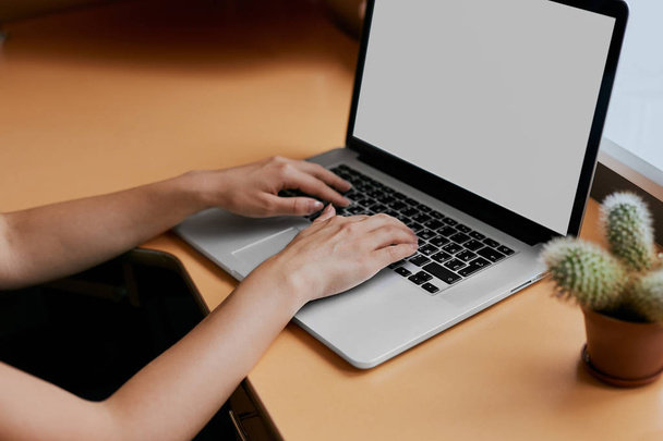 Žena psaní na její bílé přenosného počítače na pracovní stůl. - Fotografie, Obrázek