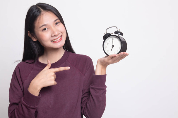 Młoda kobieta azjatyckich punkt do zegara na białym tle - Zdjęcie, obraz