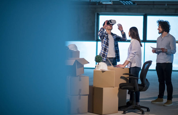 young team of business people in group, architect and engineer on construction site checking documents and business workflow using the virtual reality headset and laptop computer in new startup office - 写真・画像