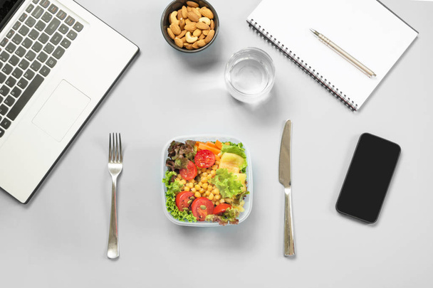 Healthy business lunch in office, salad for snack, almonds, water on blue table. Top view with copy space. Concept healthy nutrition. Lunchbox. To do list. - Foto, Bild