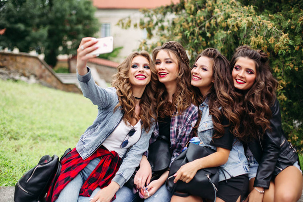 Fashionable ladies with hairstyle taking selfie outdoors. - Photo, Image
