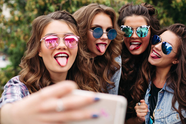 Senhoras na moda com penteado tomando selfie ao ar livre
. - Foto, Imagem